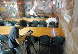 Chris Hergert adjusts the camera while shooting scenes in a restaurant for "Heaven and Hell."
