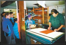 In Vermont, 5th and 6th graders at Bradford Elementary designed a brochure and map displaying local lands open to the public. Here they watch as a printer completes the job.