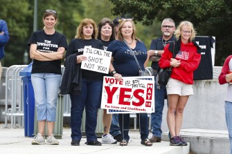 Protesters hold signs at a Moms for Liberty rally at the state Capitol in Harrisburg, Pennsylvania on October 9, 2021. About 100 people attended the rally to protest mask and vaccine mandates.