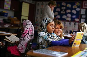 Melissa Krull looks over the shoulder of 3rd grader Samia Osman at Forest Hills Elementary School during her last week as superintendent of the Eden Prairie district.