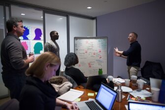 Steven Hodas, right, talks with team members of SimplifAID, “an online tool to help admitted, college-bound students better understand their educational costs and financing options” at the Startup Weekend NYC EDU event in February.