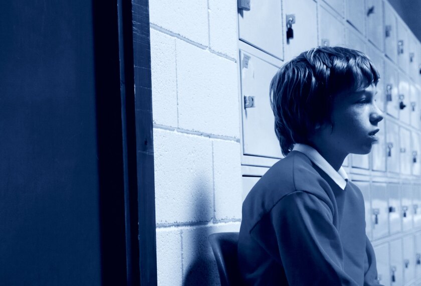 why in school suspension doesn't work schoolboy sitting on a chair isolated in a hallway
