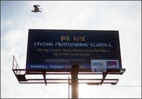 A billboard touting the district's achievements is seen in the same section of the city.
