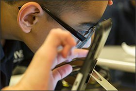 Victor Jarron, an 8th grader with visual impairments who attends STRIVE Prep-Federal, a Denver charter school, uses his specially formatted iPad during class. STRIVE Prep-Federal is among several charters in the city that are partnering with the Denver district to serve more students with disabilities.