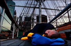 Educator Gil Rosa sleeps on the deck of a ship docked at Manhattan's South Street Seaport.