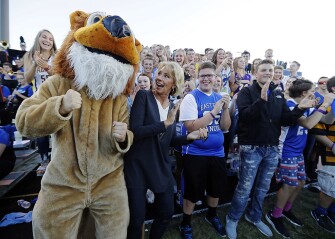 DeVos cheers with Eastern Hancock students during a high school football game between Eastern Hancock and rival Knightstown in Charlottesville, Ind.