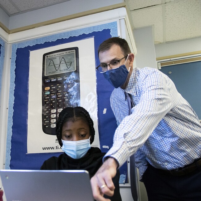 Steve McManus, the Upper School Principal of the Friends School of Baltimore, helps a student complete her independent work during his modern history class on Sept. 24, 2021.