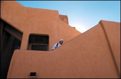 Senior Daryl Montoya pauses on the stairs as he exits the second floor of a boys' dormitory at Santa Fe Indian School. The school, in the midst of a federally financed $38million renovation project, is built in an adobe architectural style in the tradition of the Southwest.