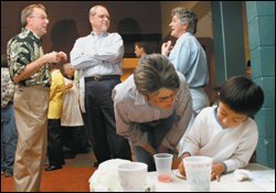 Debbie Roberts, front, tries to talk Danny Richeson, 5, into coming to a baseball game. Behind them, Danny's parents, Bill Richeson, left, and John Barnby, center, converse with Jessie Lampley during a recent after-service coffee time at St. Ann's Episcopal Church in Nashville, Tenn.