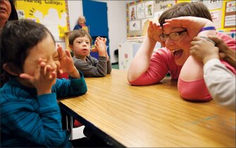 Special education teacher Elizabeth Rosenberry, right, uses singing in a lesson to encourage Jesus Torres-Tiamani, left, to make eye contact as classmate Ian Tokay looks on. The strategy comes from a federally backed arts initiative for students with severe cognitive and behavioral needs