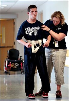 Physical therapist Whitney Thomas helps Zack Lystedt, practice walking. Washington state named its concussion law after the former athlete, who nearly died on his high school football field in Seattle.