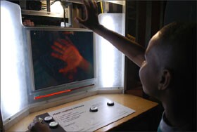 Taivon Wilson, a 6th grade student at Franklin Middle School in Vallejo, Calif., waves at a high-speed camera that plays back movements in extreme slow motion during a field trip to The Exploratorium in San Francisco.