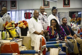 Community-outreach specialists Cynthia Battle and Brandon Phillips, both sitting, of the Pittsburgh Association for the Education of Young Children, with barbers Ron Hankins, Greg Powe and John Turner at Willy Tee’s Barbershop in Homewood. The neighborhood shop is a central location in the ‘Raising Readers Parents Club,’ and provides a safe meeting facility to help children learn.
