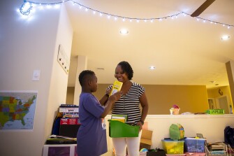 Carter Aikin, 8, picks out a book from the Diary of a Wimpy Kid series in the family’s home in Katy, TX, on Thursday, July 8, 2021.