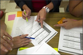 Elementary teachers in Kent County, Md., examine a common-core math progressions document during a cross-grade meeting.
