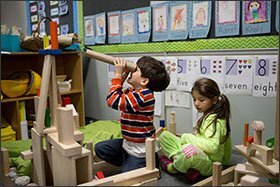 Mitchell De Araujo Silva looks through a cardboard tube in a building-block area with Lucia Nassif at Jefferson Elementary School, during a time set aside for play of their choice.