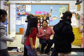 Kindergarten teacher Pat Johnson beats a drum while her students perform a traditional two-step dance during class on a recent day at the Navajo-immersion school. Kindergartners and 1st graders receive all of their instruction in Navajo.