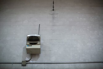 A space heater is surrounded by kickball marks in the coal dust that coats a gymnasium wall at Ansted Elementary in Fayette County, W. Va. Space heaters have replaced a once-functional basement coal furnace in the school.