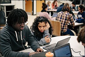 Junior De’Quan Ramsey, left, works with classmate Amina Mohamed in a co-taught U.S. Government and Civics class at Wheaton. The co-teaching system provides extra support for students who need it in lower-tier, college-prep classes.