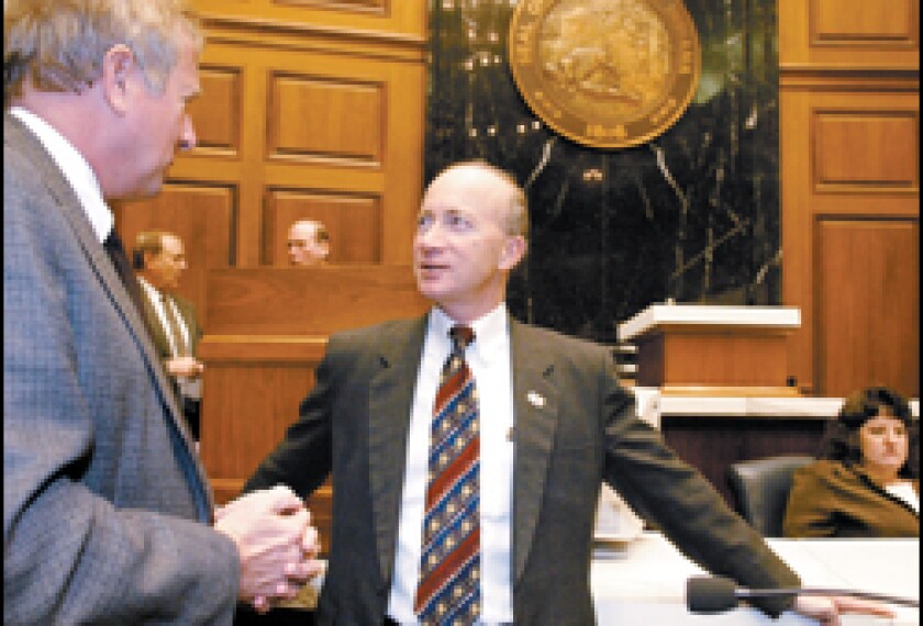 Indiana Gov. Mitch Daniels chats with Rep. Ralph Ayres following a speech on Jan. 19.