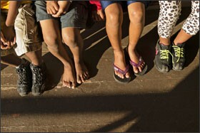 Students sit outside the principal's office at Naalehu Elementary School. The rural school has many low-income students; some may arrive at school with no shoes.