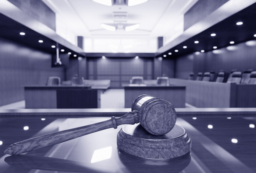 Image shows a courtroom and gavel.