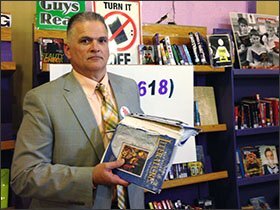 Harrisburg Schools Superintendent Mike Gauch displays a textbook which is nearly 20 years old. Gauch says his Ill. district can't afford to replace the books.
