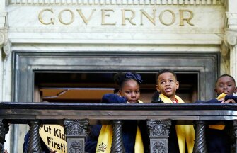 New Jerusalem Christian Academy 3rd grade students Kaniya Brown, 8, left, and Ashten Hobson, center, and Kriscian Myers II, both 9, look out at school choice rally activities in the rotunda from the Governor’s office balcony at the Capitol in Jackson, Miss., on Jan. 24.