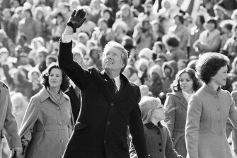 President Jimmy Carter waves to the crowd while walking with his wife, Rosalynn, and their daughter, Amy, along Pennsylvania Avenue from the Capitol to the White House following his inauguration in Washington, Jan. 20, 1977.