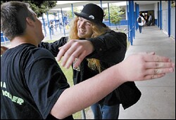 Daniel Dorman, right, hugs fellow Foghat fan Matt Smith as 'Slow Ride' plays instead of the bell.