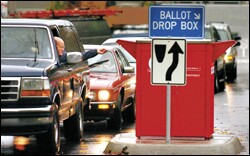 Voters line up in their vehicles to drop off absentee ballots on a rainy Election Day in Vancouver, Wash.