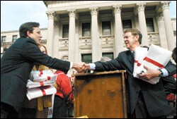 House education committee Chairman Randy Pierce, a Democrat, left, and his Senate counterpart, Republican Mike Chaney, congratulate each other after the rally, which capped a series of five-mile walks by backers of more aid.