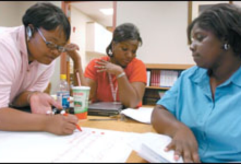 Davita Lancelin, left, Dequindra Redding, and Pamela Jordan work together at an elementary school on a project for their studies at the University of Louisiana at Lafayette.