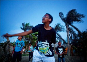 From left, VLA students Tendaji Andrews-Hutchinson, Asha Andrews-Hutchinson, Brandon Wilkins, and D’Ondre Senter throw rocks into the Yasika River during the farewell dinner and bonfire near Cabarete.