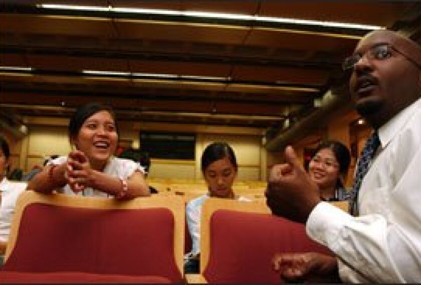 Tran Vo, left, a participant in a migrant education program in Chester County, Pa., talks with Imani Powell, right, of West Chester University last year about college admissions.