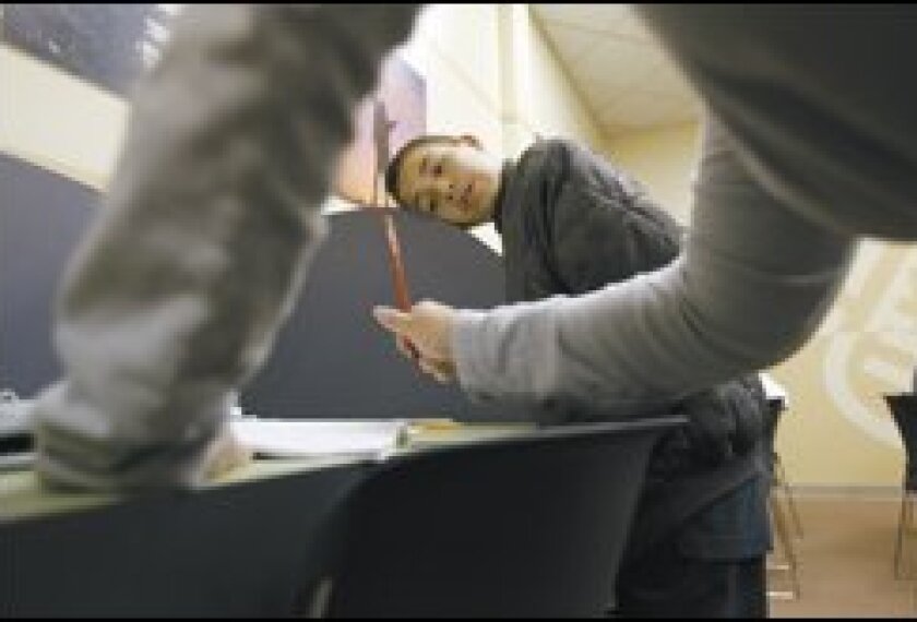 Lawrence Fierros, 13, listens as Daina Calderon, the assistant director of the Huntington Learning Center in Woodland Hills, Calif., explains a concept during a Monday-night tutoring session.