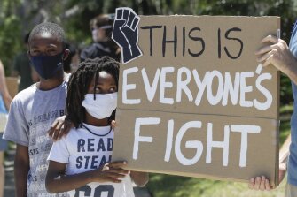 Young demonstrators hold a sign Tuesday, June 9, 2020, in Culver City, Calif. during a student-led protest over the death of George Floyd who died May 25 after he was restrained by Minneapolis police.