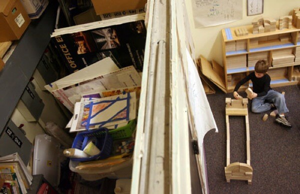 A divider beneath a 20-foot ceiling separates the kindergarten classroom from space used for computer servers and the school's telephone system as well as for general storage.