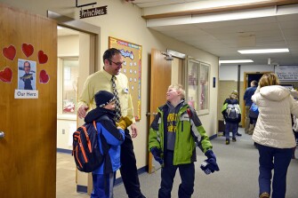 Chad Lueck, principal at Washington Elementary School in Valley City, N.D., visits with students outside his office before school. Lueck says students visit him every day.