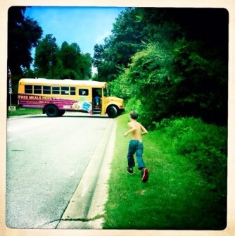 A boy runs to the lunch bus, a summer feeding program in Hudson, Fla.