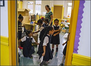 Students at P.S. 188 help clean up their classroom before the last day of the official semester in New York City public schools. The school provides an on-site nurse practitioner, mental health counseling, and other services meant to make it a hub of the community.