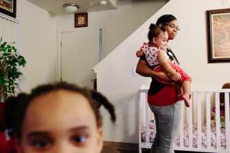 Tameka Gantt holds her youngest daughter, 1-year-old Bella Gantt, while daughter, Brooklyn Gantt, 3, looks on. Fifty families in the local Tacoma school district have agreed to keep their children enrolled in school for as long as they participate in the housing program.