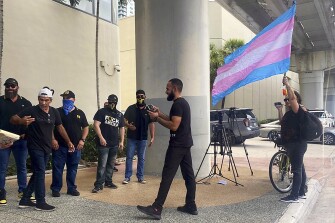 A person waving a transgender flag stands in front of a group of Proud Boys outside a contentious Miami-Dade School Board meeting discussing whether to recognize October as LGBTQ+ History Month in schools on Wednesday, Sept. 7, 2022, at the board's headquarters in downtown Miami. The board heard more than three hours of comments from students, teachers and parents before voting 8-1 to defeat the measure, which also called for teaching 12th-graders about two landmark Supreme Court cases impacting the LGBTQ communities.