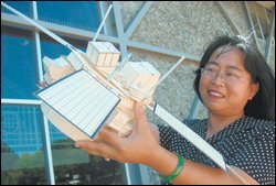 Aiming High: Elementary school science teacher Katy Kuei holds a model of a satellite that she made during her summer externship at Lockheed Martin.