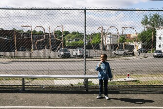Ava Moore, 5, eats ice cream on a basketball court across the street from P.S. 28.