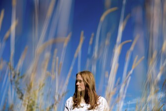 Jackie Hegarty, a rising senior at Newtown High School, poses for a photo at Holcombe Hill Wildlife Preserve, Thursday, Aug. 18, 2022, in Newtown, Conn. Hegarty, a triplet, was in second grade doing yoga with her classmates when the shooter opened fire right across the hall.