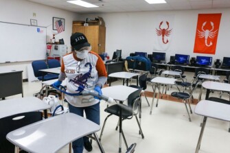 Custodial staffer Hortensia Salinas uses an Electrostatic Clorox Sprayer to spray disinfectant in a classroom March 11, 2020, at Brownsville Early College High School in Brownsville, Texas. The Brownsville Independent School District made the sprayers available to its campuses as a precautionary measure against the spread of the coronavirus.