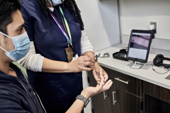 Jones Senior High School nurse Diane Haddock demonstrates on Jones Senior High School student Cesar Morill how she uses the telemedicine station to gather information about a student's health, which is then passed along to a physician who then consults directly with the student. The session is one function of the telemedicine program implemented by Jones County Superintendent Ben Thigpen, in partnership with Eastern Carolina University.