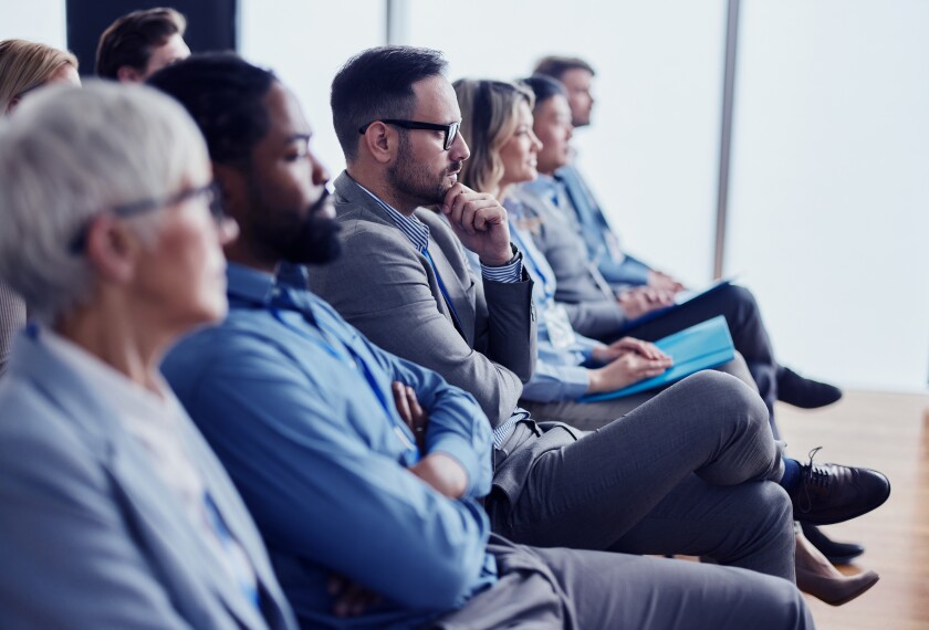 Photograph of thoughtful, diverse, business group attending a seminar in board room.