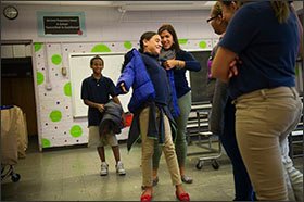 Wraparound counselor Jennifer Jimenez hands out coats to students.